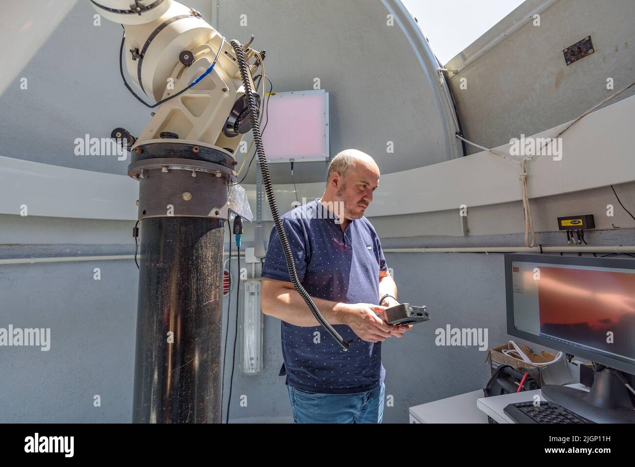 Salvador Ribas, direttore del Centro di osservazione dell'Universo, manovrando un telescopio al Parco Astronomico di Montsec, a Àger (Lleida, Catalogna) Foto Stock