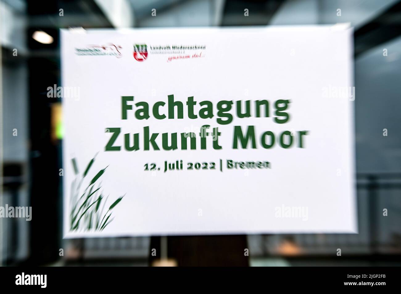 Brema, Germania. 12th luglio 2022. 'Fachtagung Zukunft Moor' è scritto su un cartello. In occasione della conferenza, gli agricoltori della bassa Sassonia discutono delle misure di protezione del clima nelle zone di allevamento e delle possibili conseguenze per le aziende agricole. Credit: Sina Schuldt/dpa/Alamy Live News Foto Stock