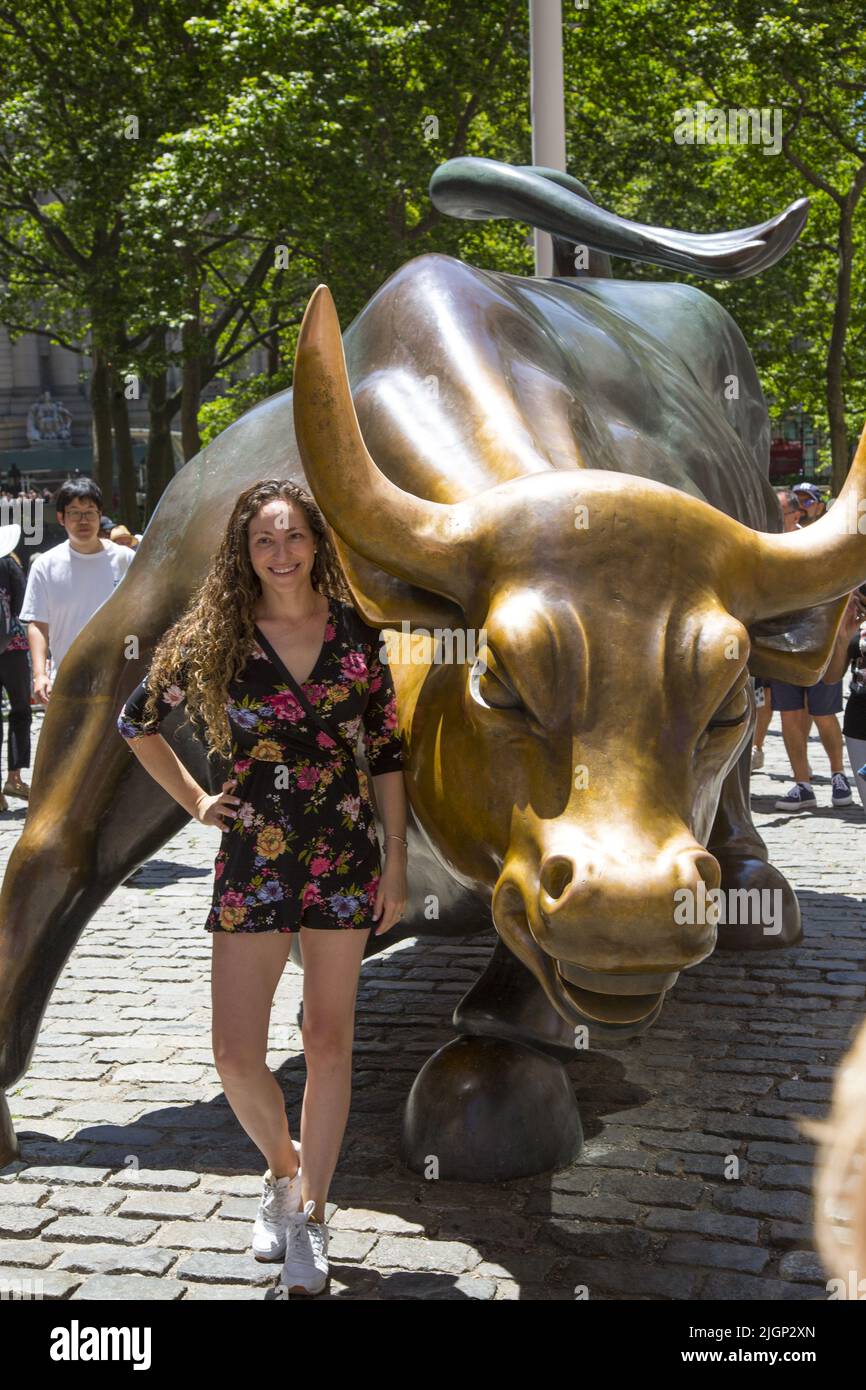 I turisti si allineano per scattare le loro foto con il famoso Wall Street Bull lungo Lower Broadway a Manhattan, New York City. Foto Stock