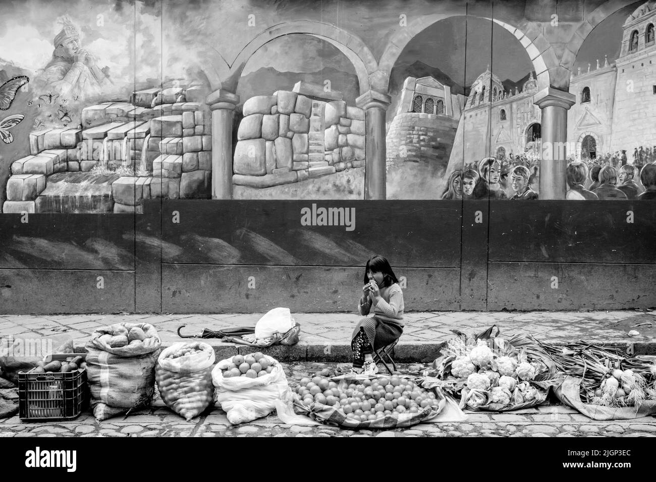 Un bambino che vende frutta e verdura mangia il pranzo in un mercato di strada all'aperto di frutta e verdura, Cusco, provincia di Cusco, Perù. Foto Stock