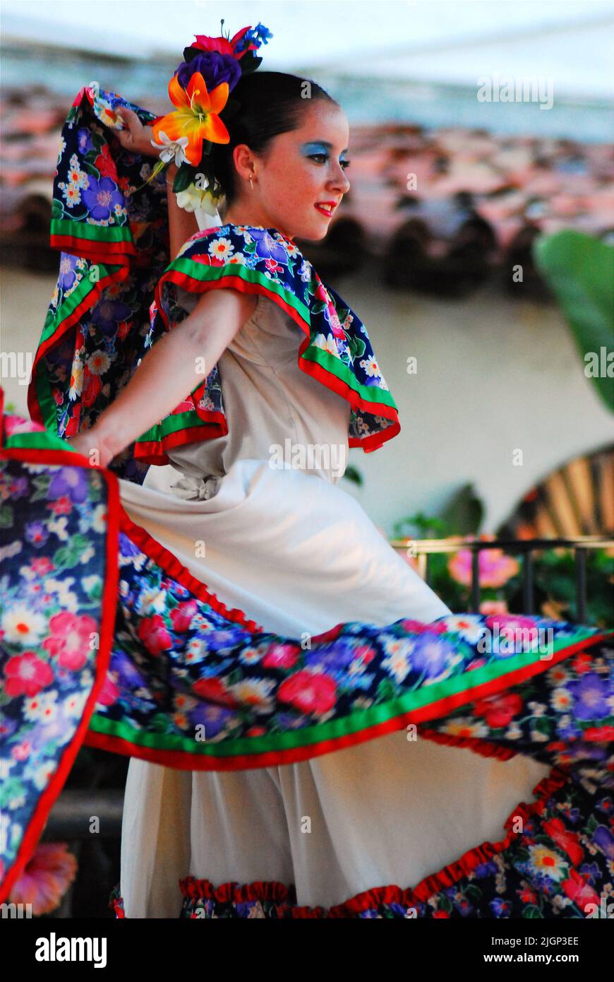 Una giovane donna che indossa un abito tradizionale partecipa ad uno spettacolo e ad uno spettacolo che mette in risalto la cultura della danza del Messico e della musica messicana Foto Stock