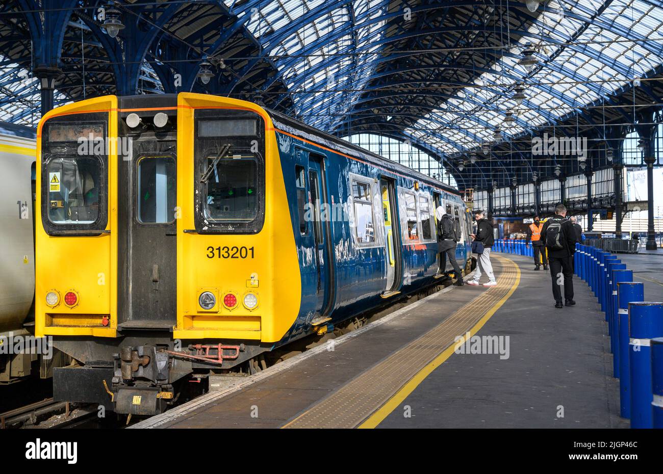 I passeggeri salgano a bordo di un treno British Rail classe 313 nella livrea meridionale, stazione ferroviaria di Brighton, Inghilterra. Foto Stock