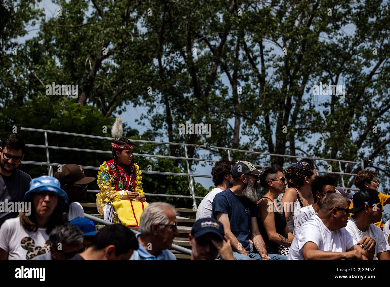 La gente guarda i ballerini di Pow-wow che indossano costumi tradizionali durante il festival. Foto Stock