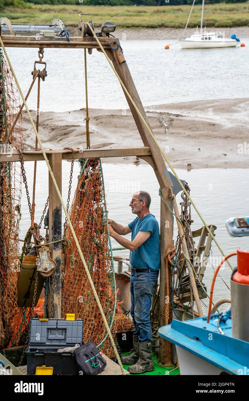 UN PESCATORE A WIVENHOE (VICINO A COLCHESTER) RIPARA LE RETI Foto Stock