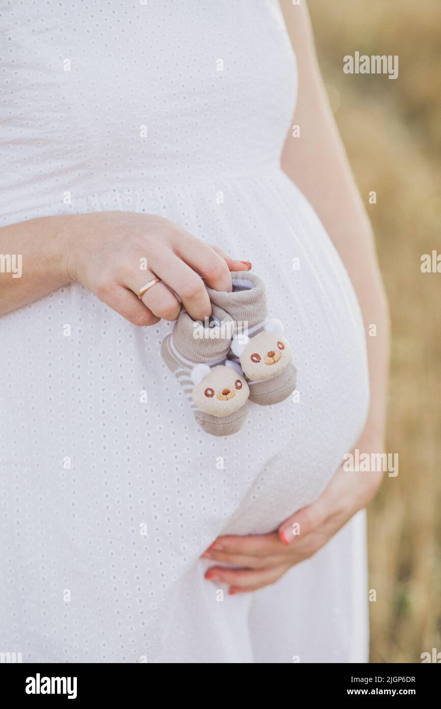 Gravidanza, maternità, persone e concetto di aspettativa - primo piano di felice donna incinta con grande ventre su sfondo naturale. Bella donna incinta Foto Stock