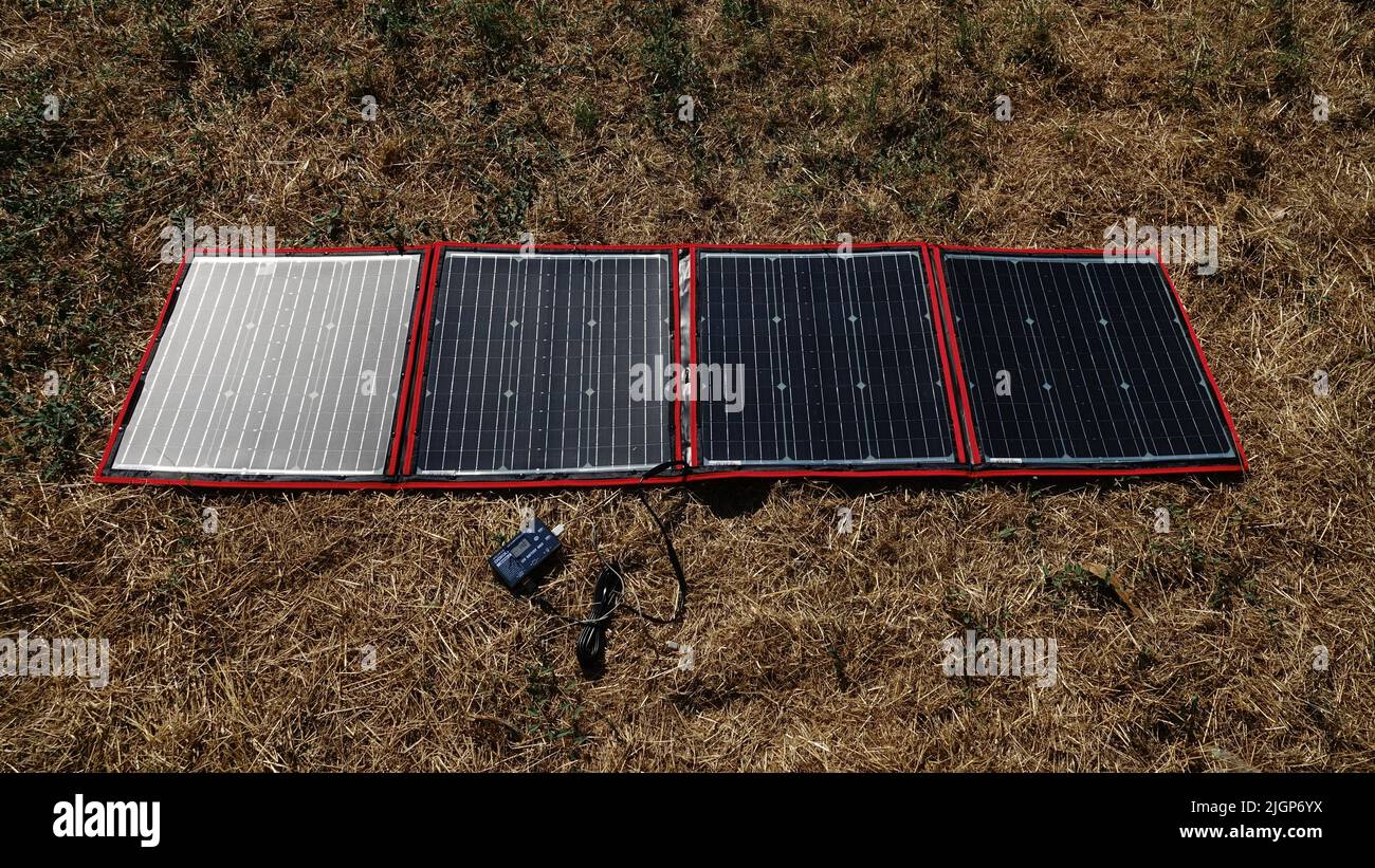 Un pannello solare pieghevole e portatile si apre su un prato Foto Stock