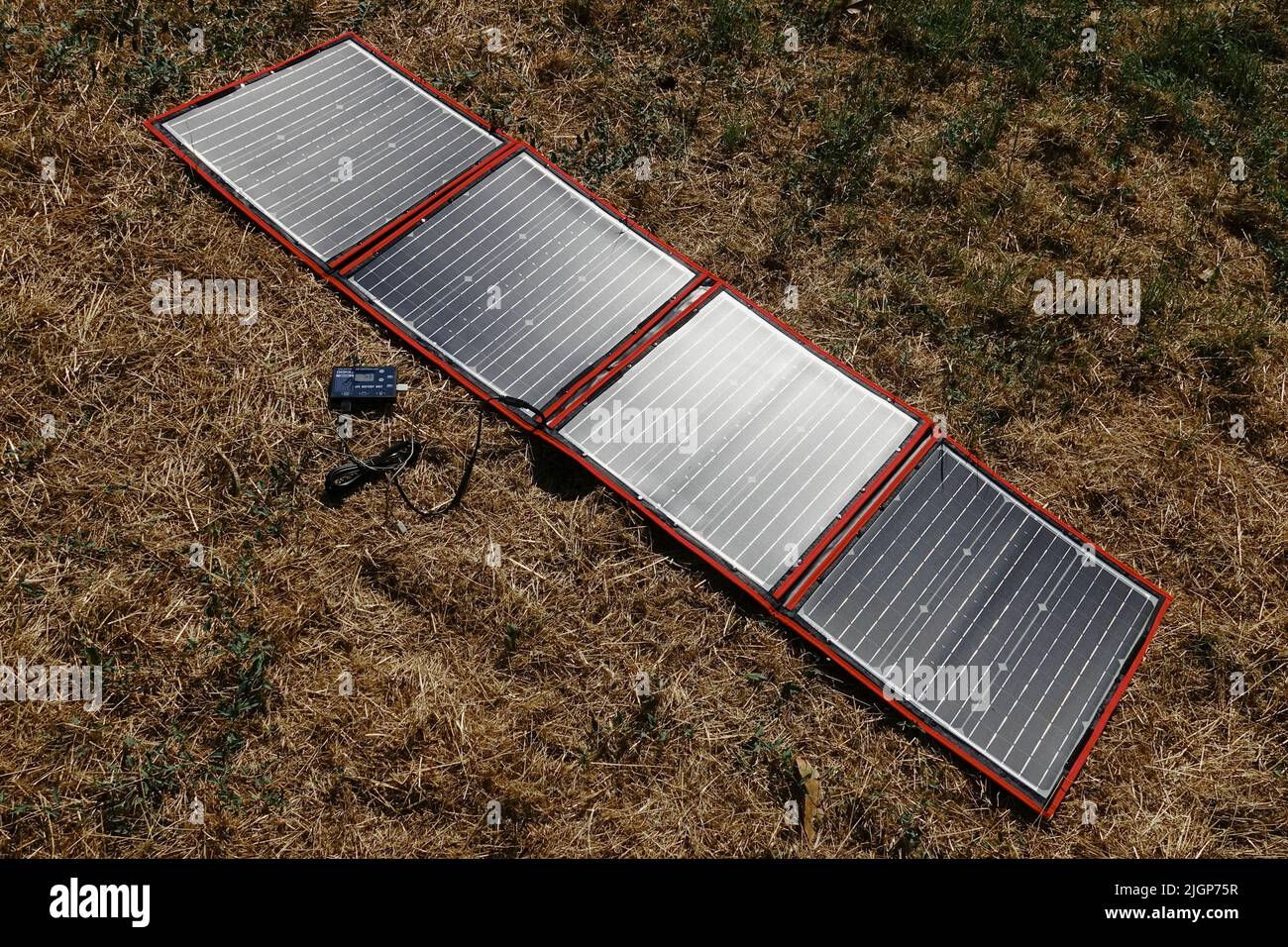 Un pannello solare pieghevole e portatile si apre su un prato Foto Stock
