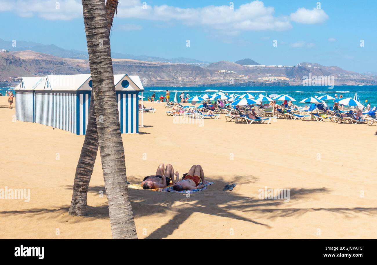 Las Palmas, Gran Canaria, Isole Canarie, Spagna. 12th luglio, 2022. Dopo un fine settimana con temperature superiori a 40 gradi Celsius su Gran Canaria, i turisti godono di una giornata meno soffocante sulla spiaggia della città di Las Palmas con la temperatura intorno a 30 gradi Celsius il Martedì. Credit: Alan Dawson/ Alamy Live News. Foto Stock