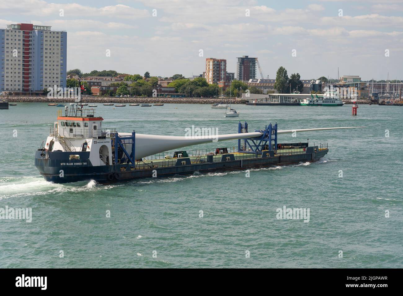 Portsmouth, Inghilterra meridionale, Regno Unito. 2022. Pala della turbina eolica come carico sulla pala corridore due nave in corso nel porto di Portsmouth. Sfondo di Gosport, Foto Stock