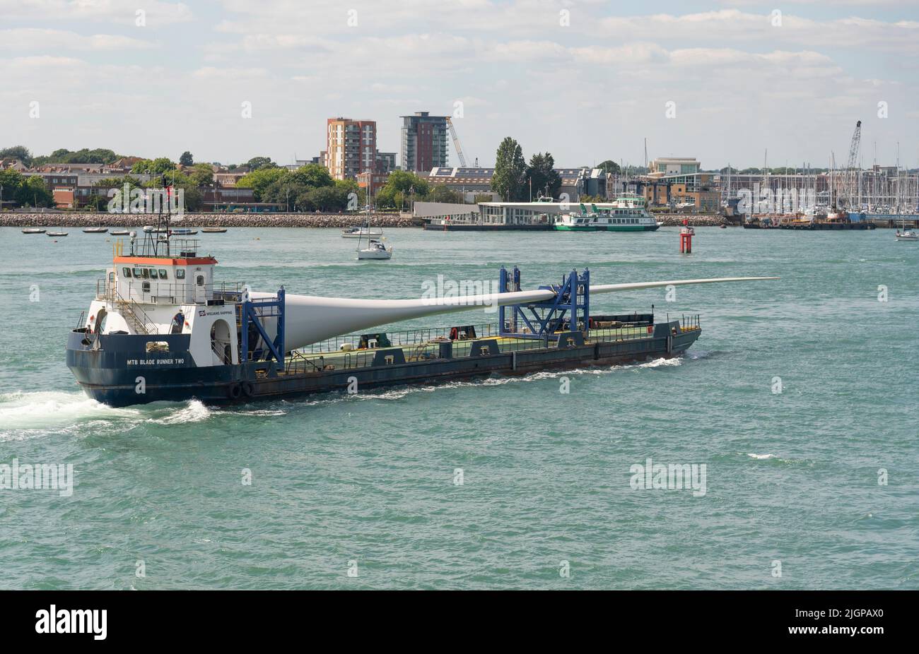 Portsmouth, Inghilterra meridionale, Regno Unito. 2022. Pala della turbina eolica come carico sulla pala corridore due nave in corso nel porto di Portsmouth. Sfondo di Gosport, Foto Stock