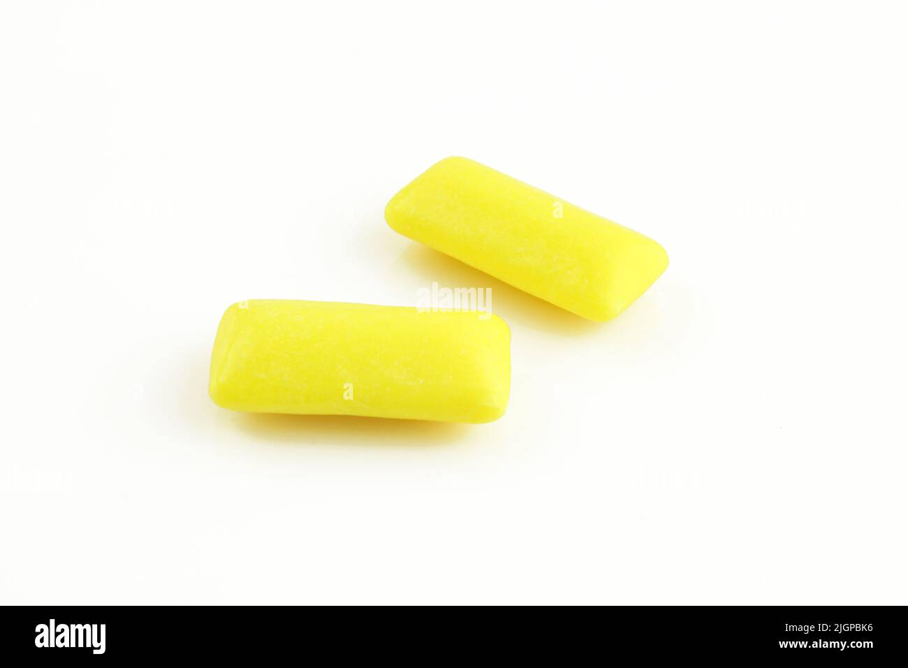 Due gengive gialle di menta piperita isolate su sfondo bianco. Gorgoglii masticanti Foto Stock