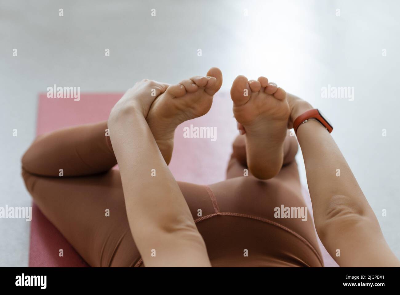 yoga asana attività deflessione sullo stomaco primo piano delle mani prese le gambe. Body Stretching Fitness e Pilates Foto Stock