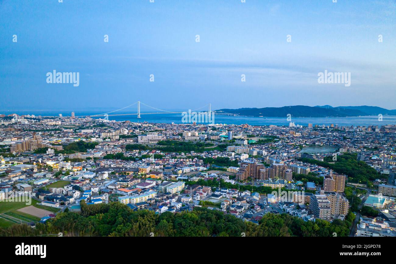 Vista aerea della città di Akashi e dell'isola di Awaji con ponte in lontananza all'ora blu Foto Stock