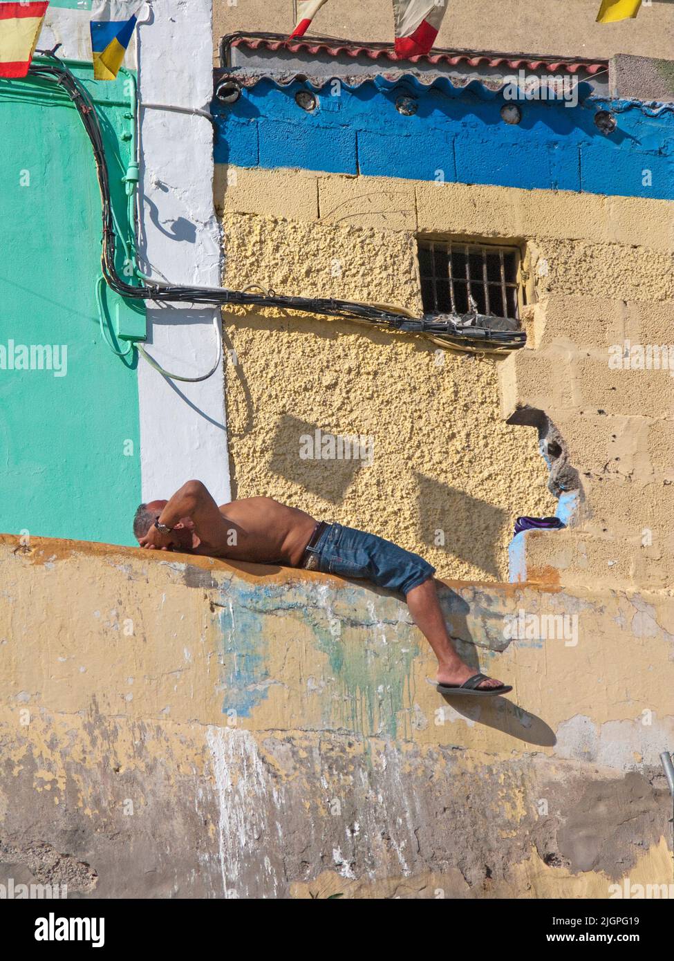 Uomo che dorme di fronte ad una casa, disrict San Nicolas, Las Palmas, Grand Canary, isole Canarie, Spagna, Europa Foto Stock