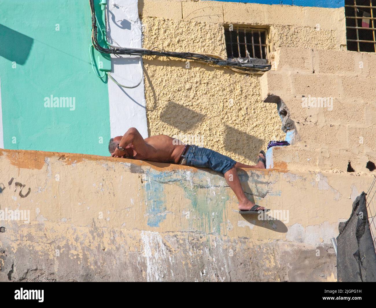 Uomo che dorme di fronte ad una casa, disrict San Nicolas, Las Palmas, Grand Canary, isole Canarie, Spagna, Europa Foto Stock