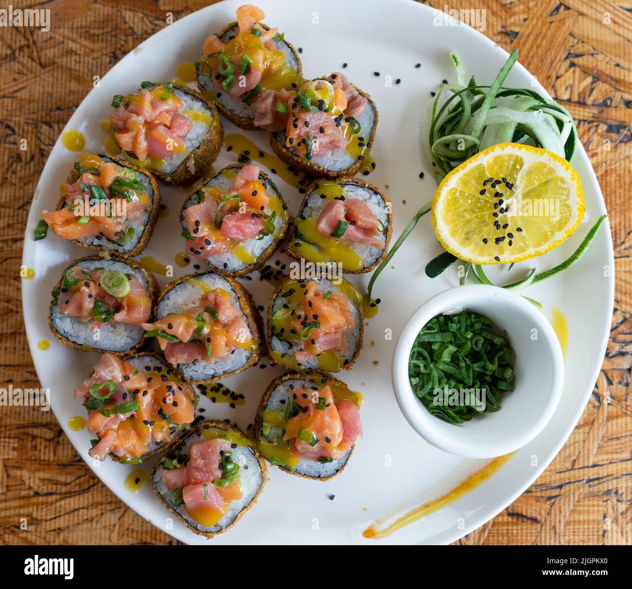 Piatto di sushi a rulli con vista dal bordo superiore del salmone e della salsa. Tradizionale cucina giapponese di stile messicano Foto Stock