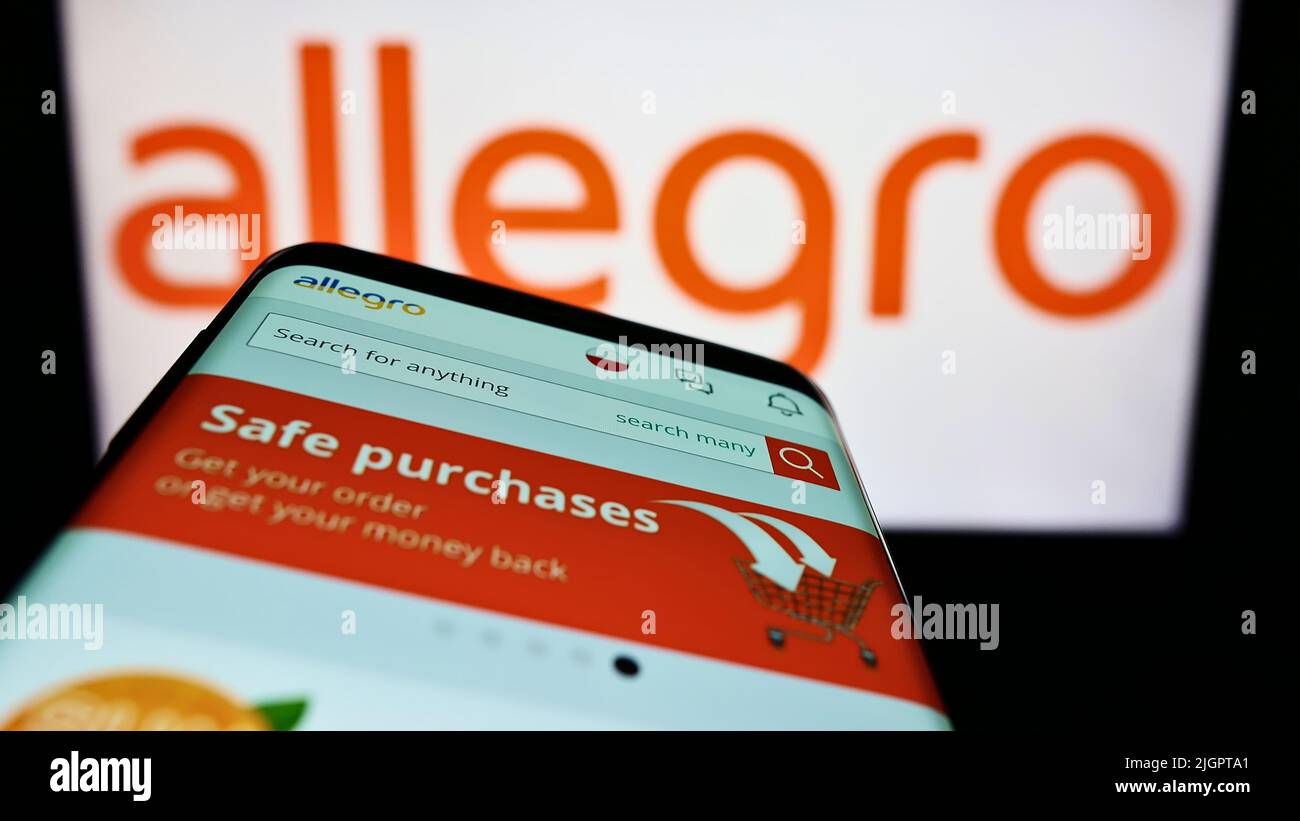 Telefono cellulare con pagina web della società polacca di e-commerce Allegro.pl Sp. z o. o. sullo schermo di fronte al logo. Mettere a fuoco sulla parte superiore sinistra del display del telefono. Foto Stock