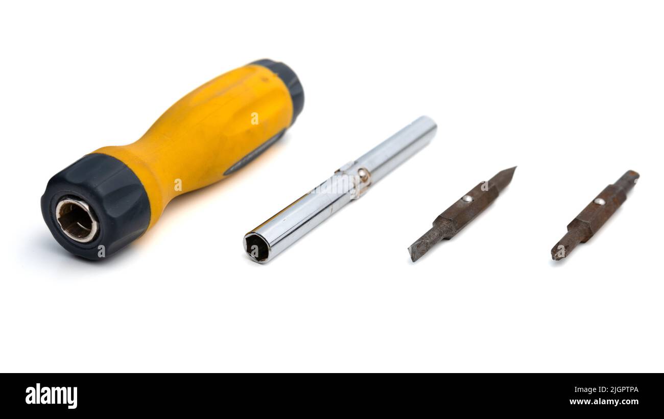 Cacciavite multi-bit con punte sostituibili su sfondo bianco. Vista ravvicinata dell'attrezzatura di riparazione. Messa a fuoco selettiva sugli oggetti Foto Stock