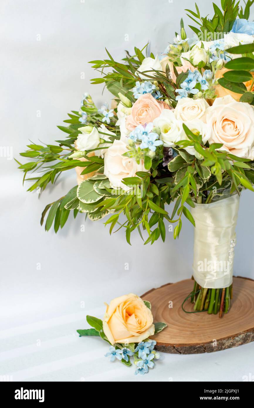 Bouquet Brides e abito coordinato boutonniere con rose e piccoli fiori blu, vista ritagliata con spazio copia. Foto Stock