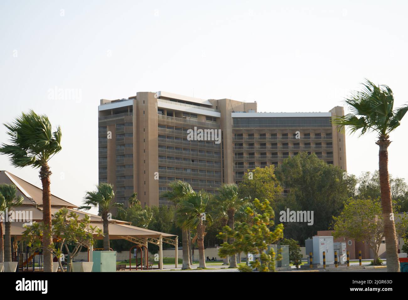 alto edificio dal cielo blu, con alcune palme e tempo ventoso. Arabia Saudita, Khobar, 10, giugno 2022. Foto Stock