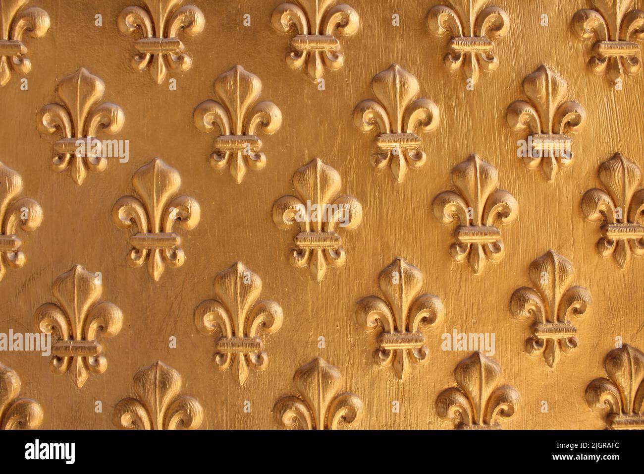 Motivo Fleur de Lis verniciato oro su tessuto di legno per sfondo. Pattern fleur-de-lis ripetuto. Foto Stock