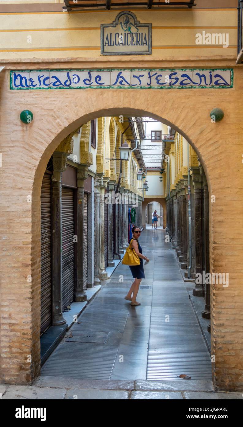 Alcaicería de Granada, strada stretta con bazar moreschi di abbigliamento e artigianato Foto Stock