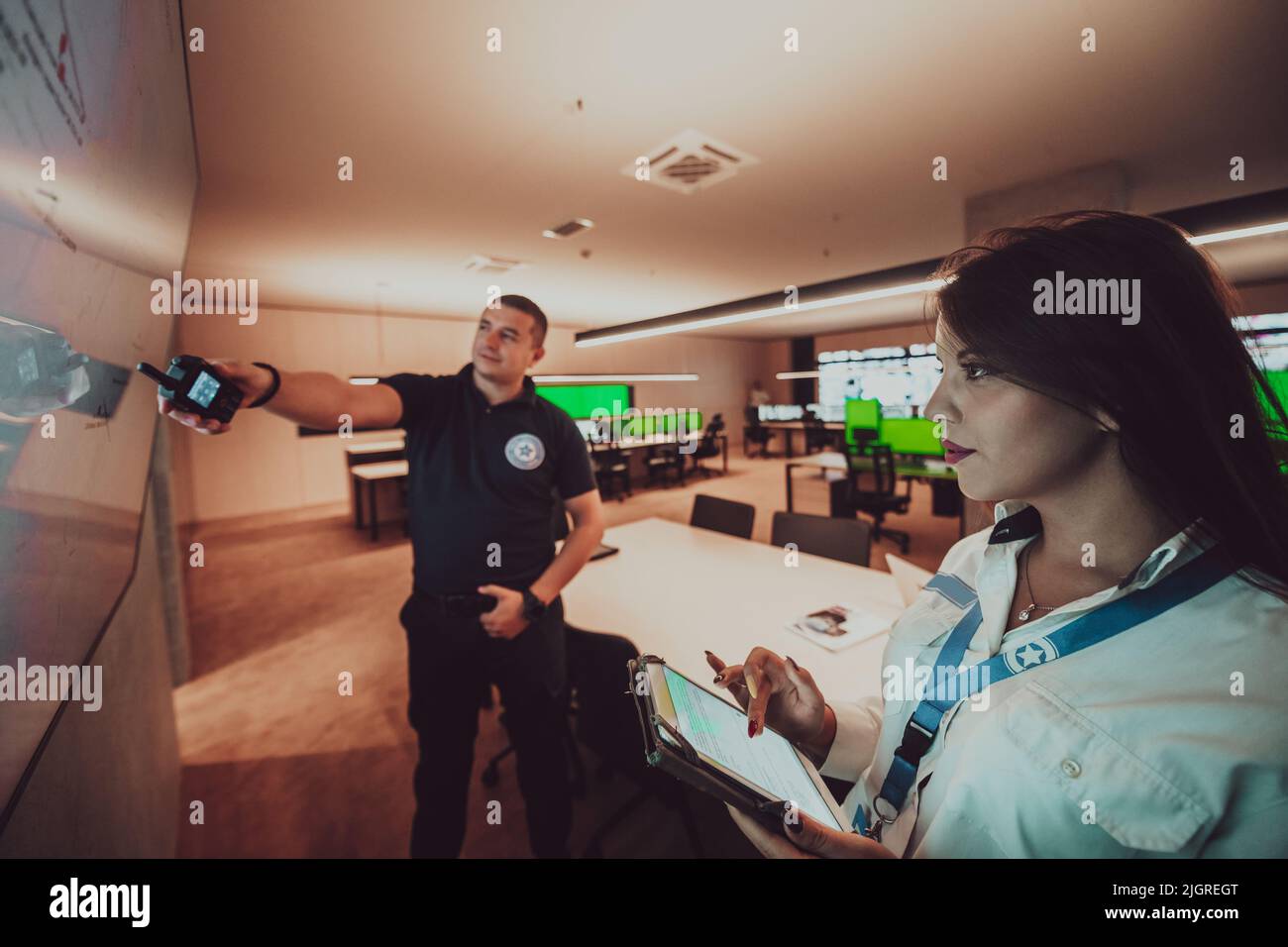 Gruppo di operatori del data center di sicurezza che lavorano in una sala di monitoraggio TVCC alla ricerca di più monitor funzionari che monitorano più schermi per Foto Stock