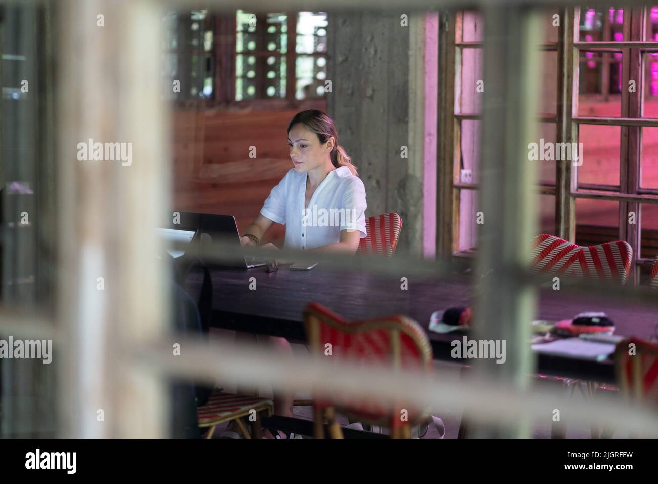 Donna studentesca che naviga in informazioni sul laptop, guardando il video corso seduto al collegio pubblico Foto Stock