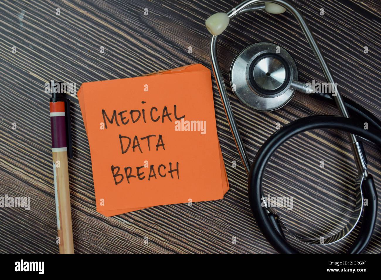 Concetto di violazione dei dati medici scrivere su note adesive isolate su tavola di legno. Foto Stock