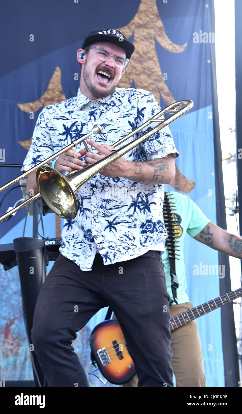 Il cantante e trombonista James Begin si esibisce sul palco durante un concerto dal vivo con Tropidelic. Foto Stock