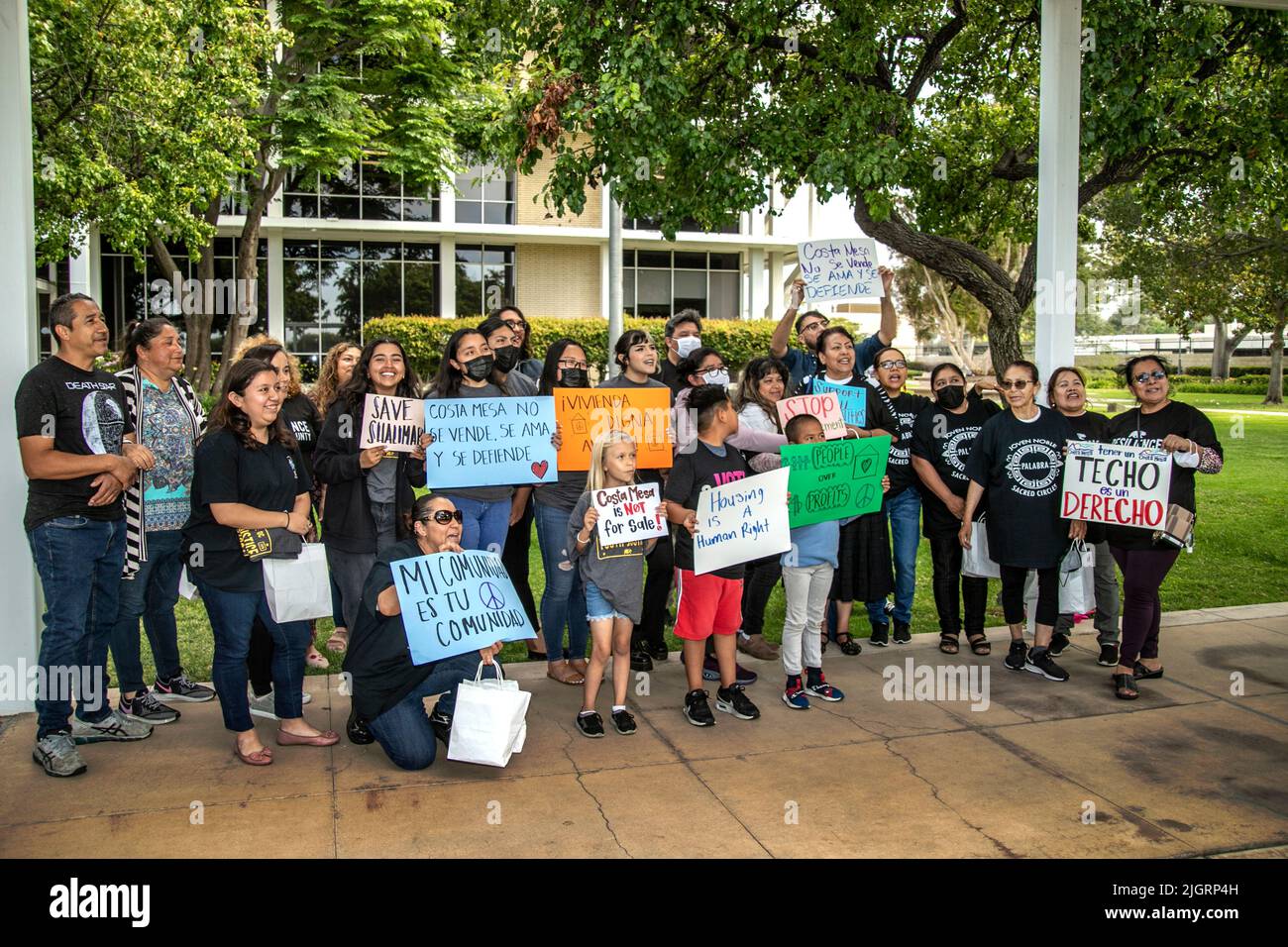 Un gruppo di manifestanti per lo più ispanici porta segnali che richiedono il controllo del canone di affitto per una riunione del consiglio comunale a Costa Mesa, CA. Foto Stock