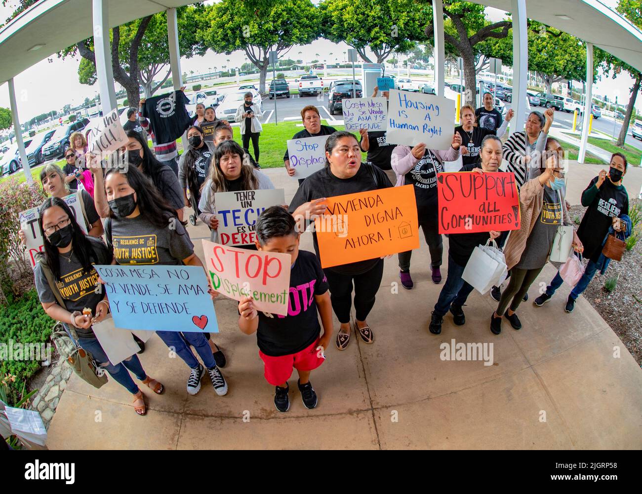 Un gruppo di manifestanti per lo più ispanici porta segnali che richiedono il controllo del canone di affitto per una riunione del consiglio comunale a Costa Mesa, CA. Foto Stock