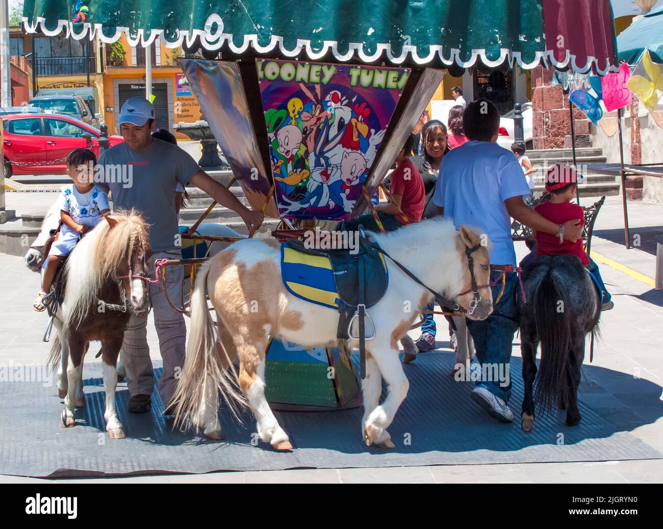 Un allegro del fairground va intorno usando i ponies reali in Tepozotlan, stato del Messico, Messico Foto Stock