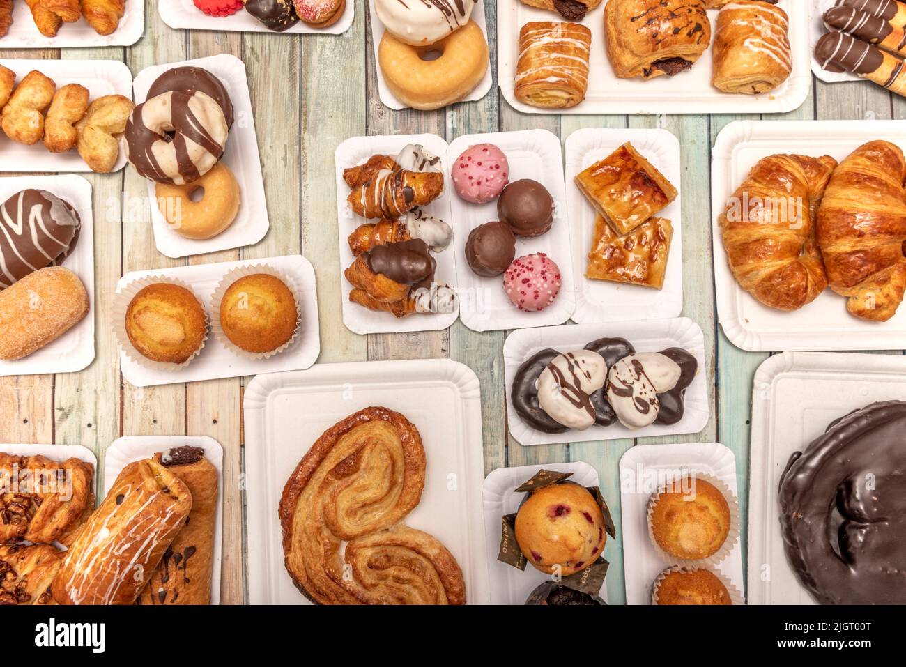 Set di vassoi di cartone bianchi con dolci, dessert e palme al cioccolato, cupcake, ciambelle al cioccolato, palle di cioccolato e cocco e palme da zucchero su woo Foto Stock