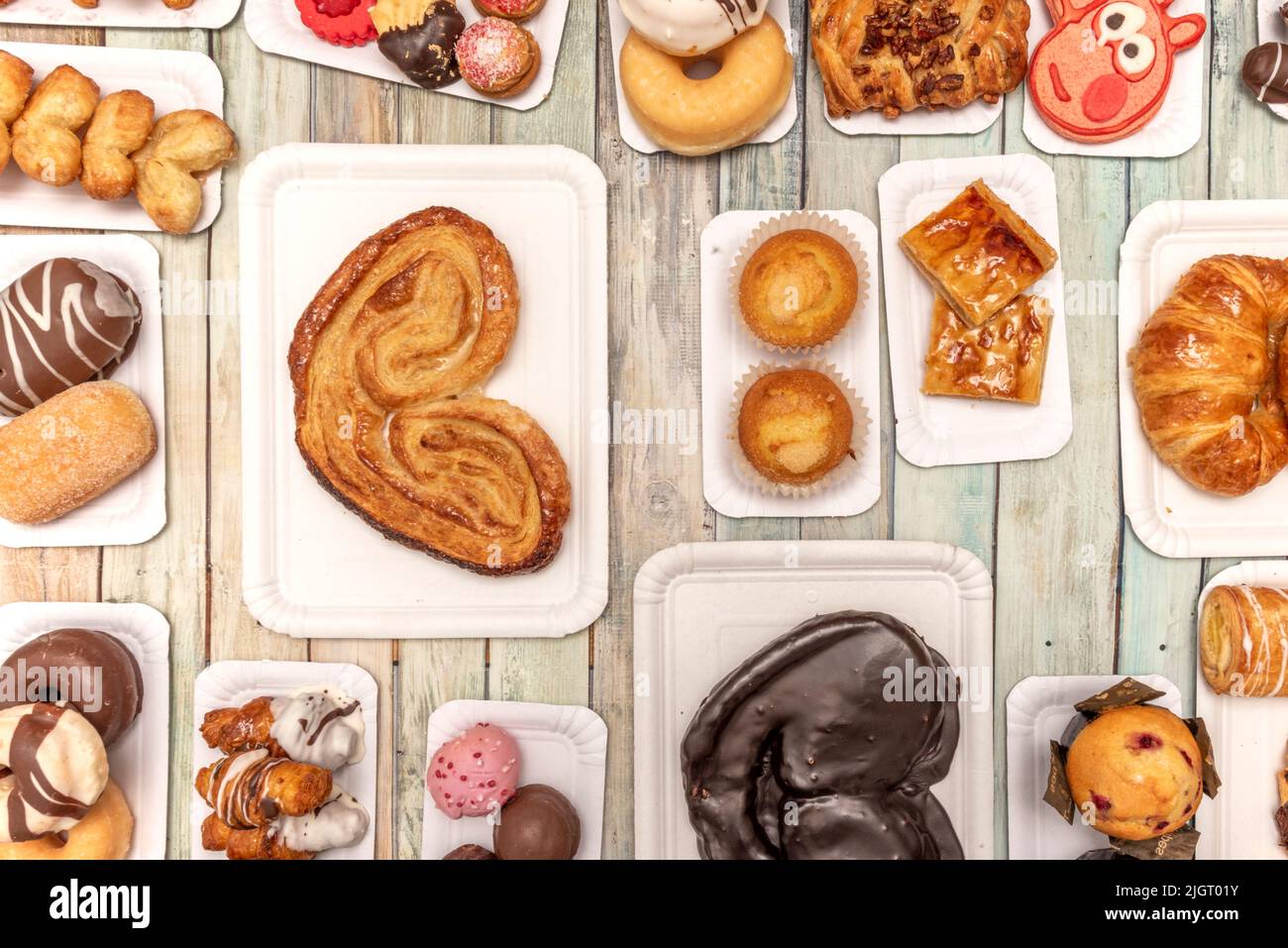Set di vassoi di cartone bianchi con dolci, dessert e palme da cioccolato, muffin, ciambelle di cioccolato, palle di cioccolato e cocco e zucchero palma tre Foto Stock