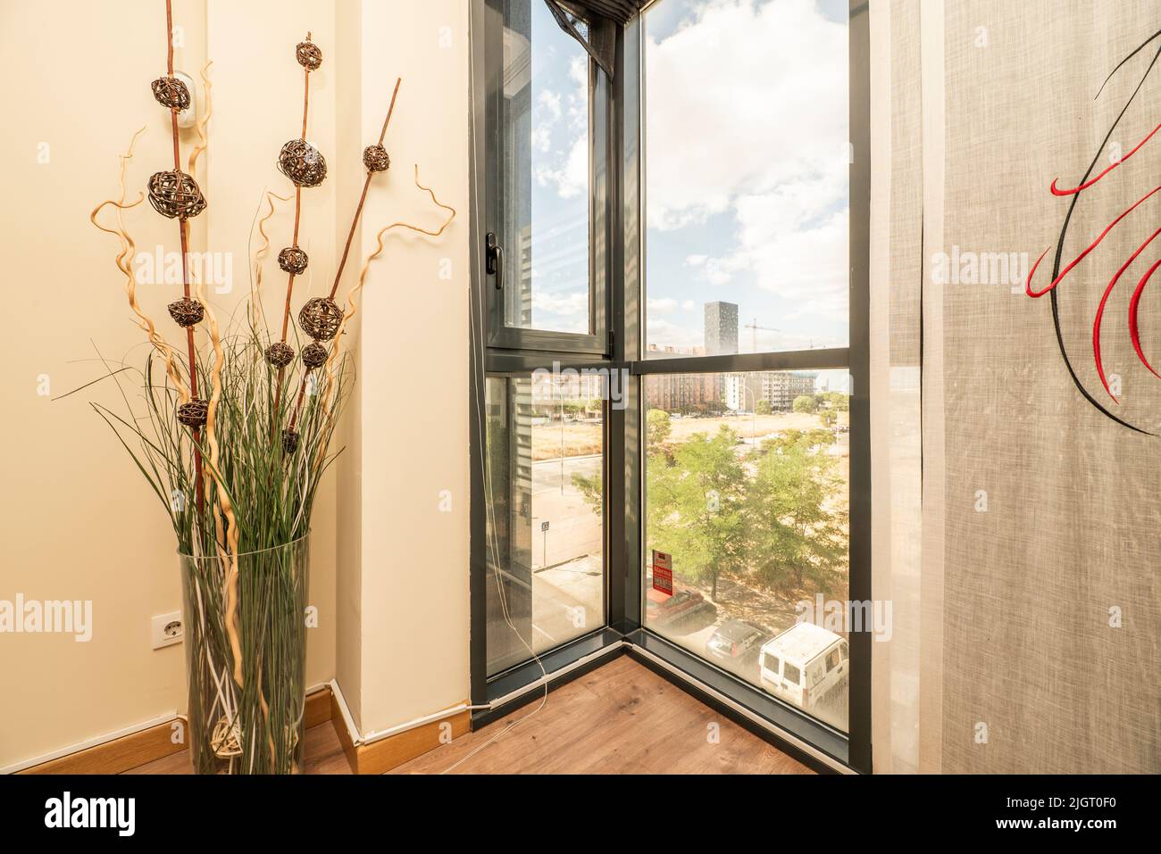 Finestra di baia di una casa con finestre in alluminio nero e un vaso con piante essiccate decorative Foto Stock