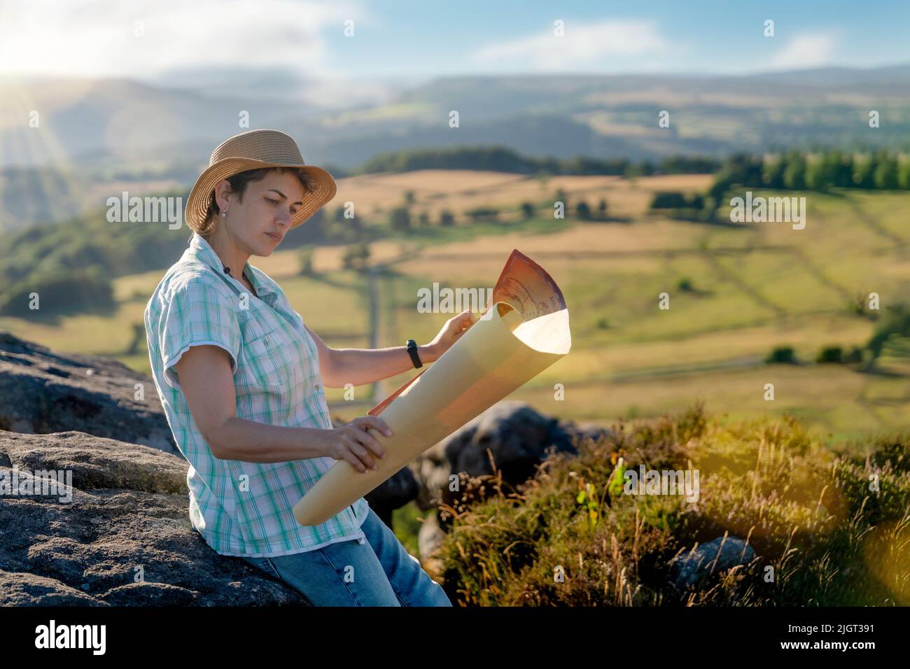 Donna in cappello guardando il carrello contro i campi che aumentano il vostro settore turistico locale Foto Stock