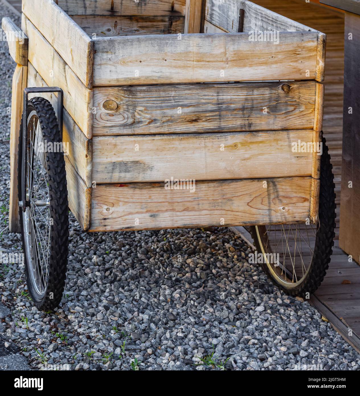 Un carro in legno d'epoca su una strada. Una strada con box in legno che distributore automatico di biciclette. Nessuno, foto di strada. Foto Stock