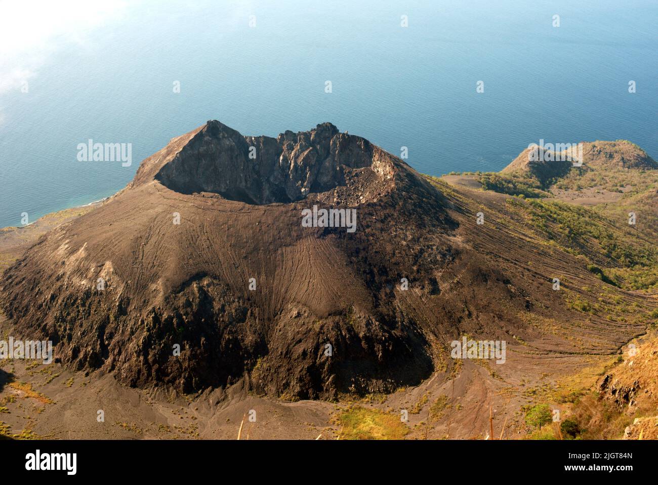 Caldera del vulcano del Monte Werung sullo sfondo del Mare di Savu, visto dal Monte Mauraja ad Atadei vicino alla costa meridionale dell'Isola di Lembata a Lembata, Nusa Tenggara Est, Indonesia. Foto Stock
