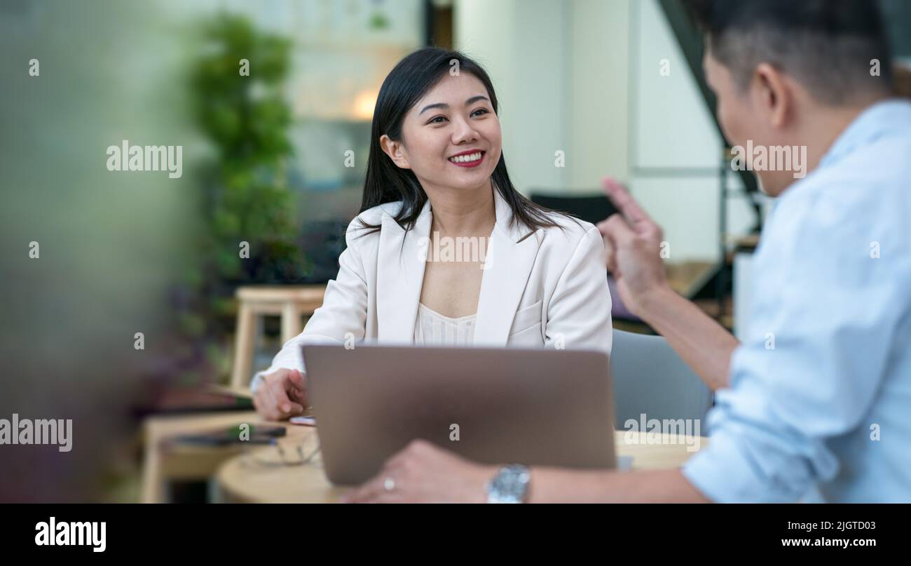 Ritratto di una bella donna d'affari asiatica sorridente in un incontro d'affari. Foto Stock