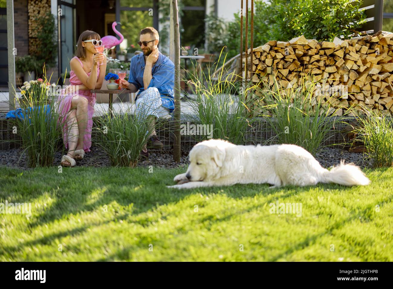 Coppia elegante trascorrere il tempo estivo con il cane sul cortile Foto Stock