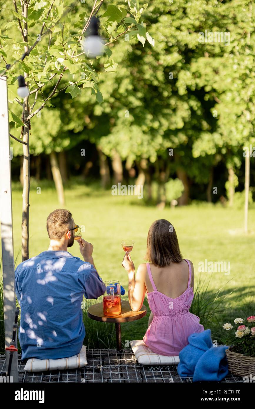 Una giovane coppia trascorre il tempo estivo con un drink sulla natura Foto Stock
