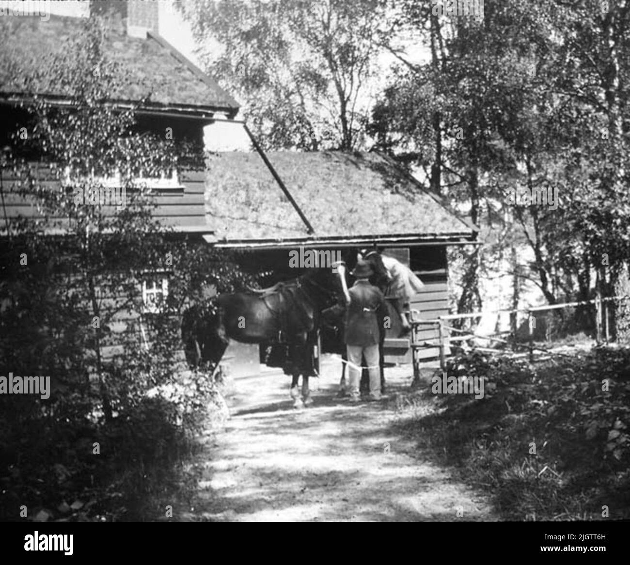 Sjöstugan su Banvägen in Pixbo. La foto è probabilmente di Banvägen in Pixbo nel comune di Råda, ora comune di Härryda. La casa è generalmente chiamata Sjöstugan. L'uomo con le spalle al fotografo è probabilmente Edvard Lithander, nato a Gothenburg nel 1870, morto nel 1944. Controllato un'immagine della collezione privata di immagini Edvard Lithander scattata all'inizio del 1900s. Lithanders visse a Pixbo su Banvägen per molto tempo. Lo stesso Lithander era direttore e parlamentare. Foto Stock