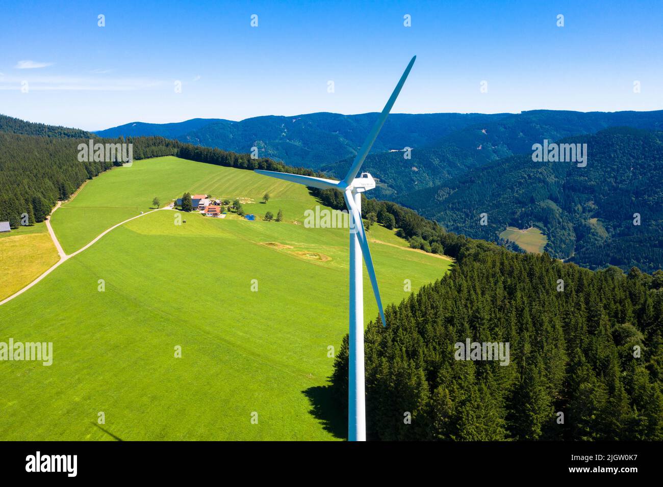 Vista aerea della centrale eolica nel verde e luminoso prato e abeti. San Pietro, Foresta Nera, Germania. Concetto di energia rigenerativa. Foto Stock