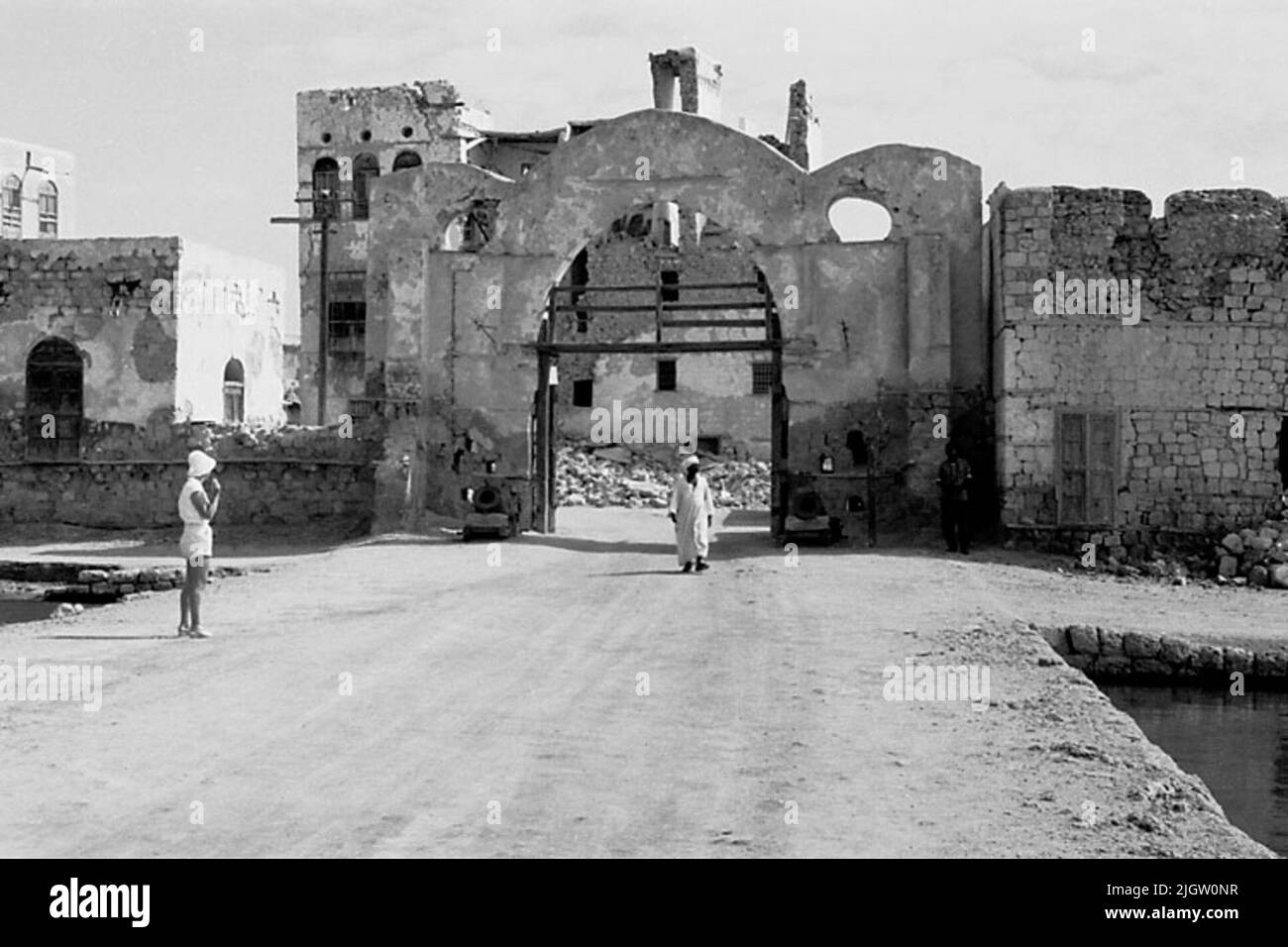 La foto è stata scattata intorno al 1961-08-22. Uno sport di città ad una società parzialmente rovinata. Fuori dalla porta si trova una donna e un uomo. African travel35 immagini in serie. Foto Stock