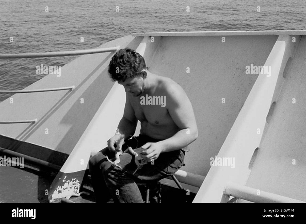 La foto è stata scattata intorno al 1961-09-22. Un uomo siede su una nave. Sta dividendo il legname di un treno. African travel35 immagini in serie. Foto Stock