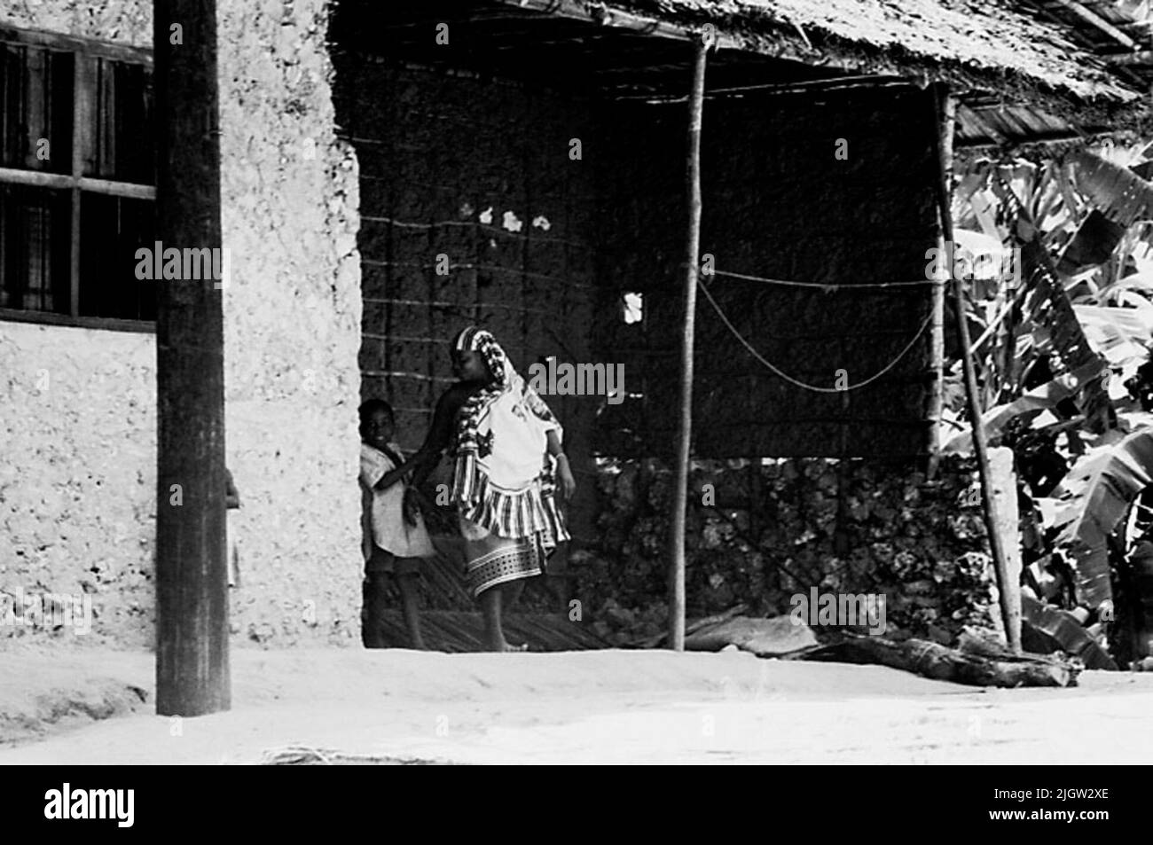 African journey, zanzibars acquisizione semplice: Libri e materiale di archivio.35 immagini in serie. La foto è stata scattata intorno al 1961-09-12. Una donna e un bambino si trovano al di fuori di un edificio residenziale. Foto Stock