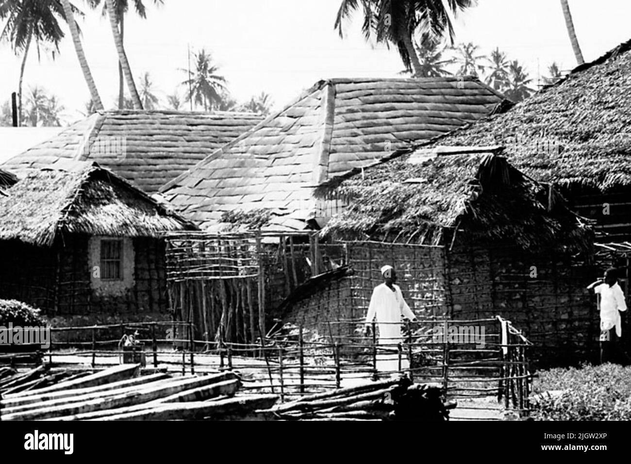 African journey, zanzibars acquisizione semplice: Libri e materiale di archivio.35 immagini in serie. La foto è stata scattata intorno al 1961-09-12. Un uomo cammina in un giardino recintato, di fronte ad alcuni edifici residenziali. Foto Stock
