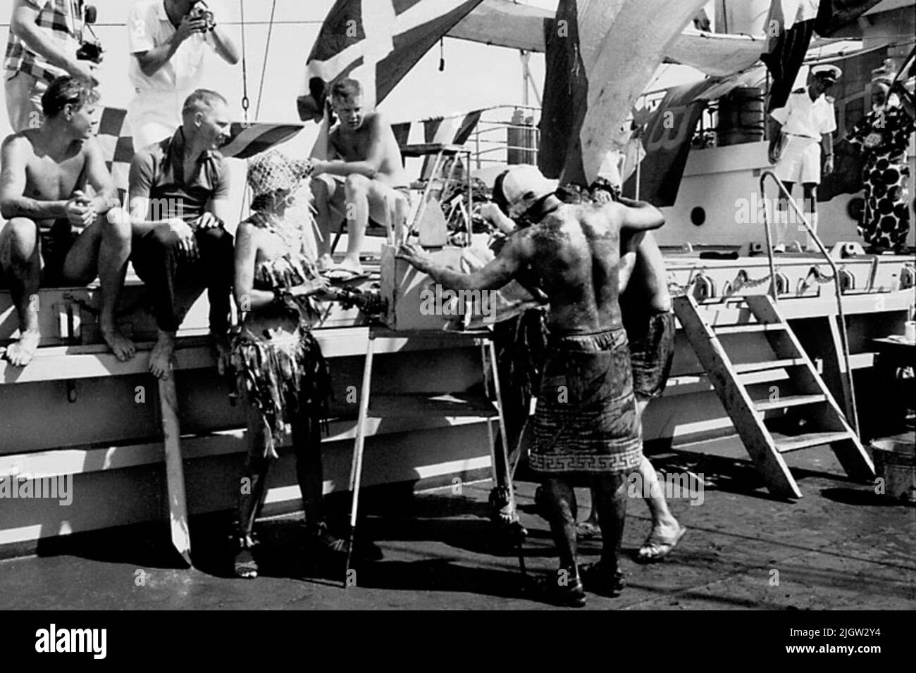 La foto è stata scattata intorno al 1961-09-02. Linea per chi passa l'equatore per la prima volta. Sul ponte è una scena preparata. Due uomini vestiti come guardie carcerarie, costringono un 'verde' a mettere la testa in una scatola. Viaggio africano, Aden Linjedop.36 immagini in serie. Foto Stock