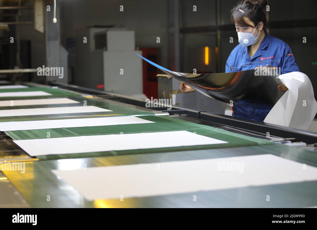 CHENGDE, CINA - 11 LUGLIO 2022 - Un lavoratore controlla la qualità del rivestimento fotosensibile su lastra di stampa in una fabbrica di lavorazione di lastre di stampa a che Foto Stock